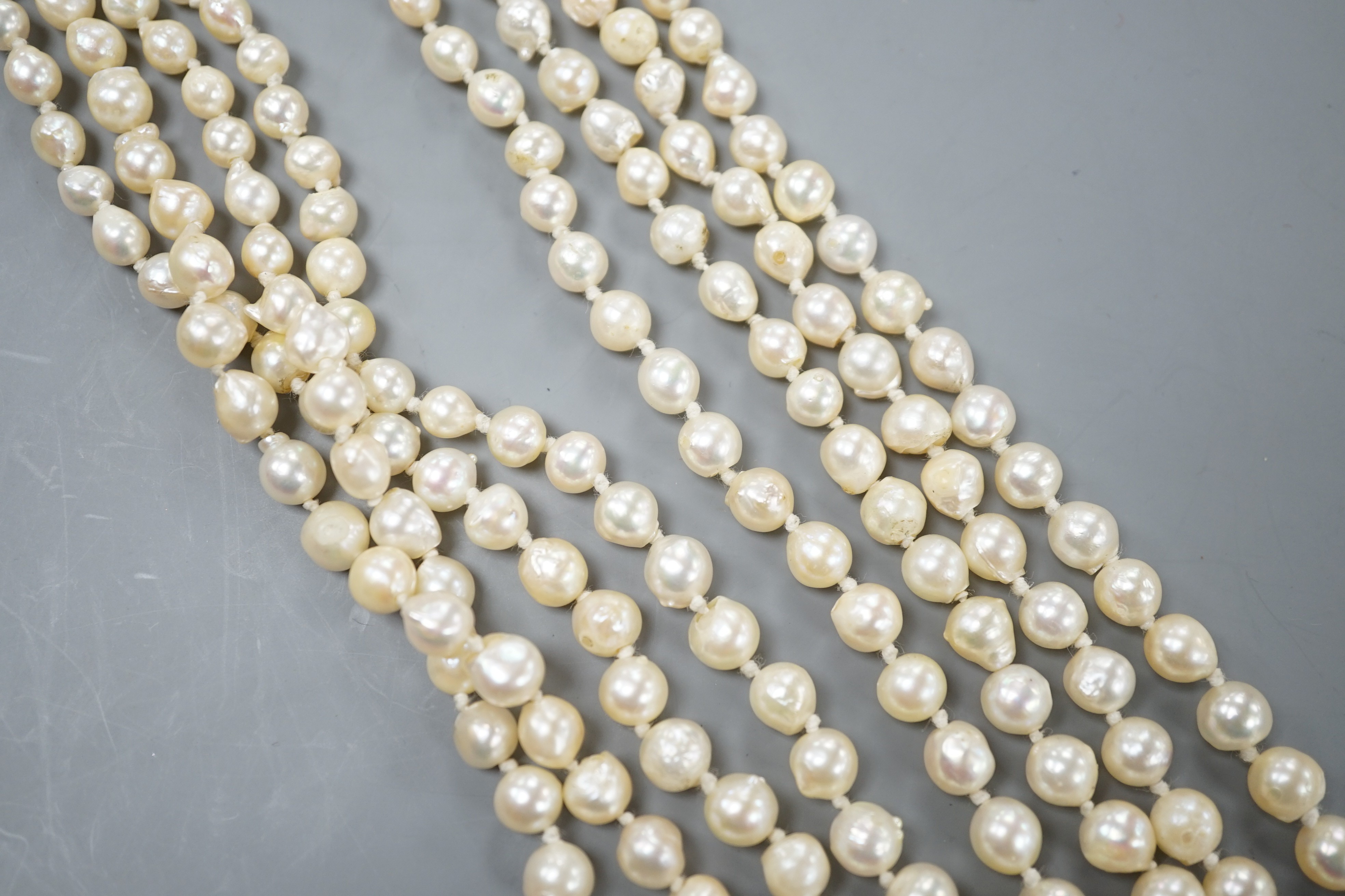 A 1960's triple strand cultured pearl necklace, with garnet and seed pearl set 9ct gold clasp, 48cm.